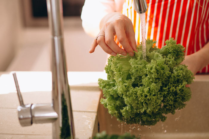 Hands close up washing lettuce